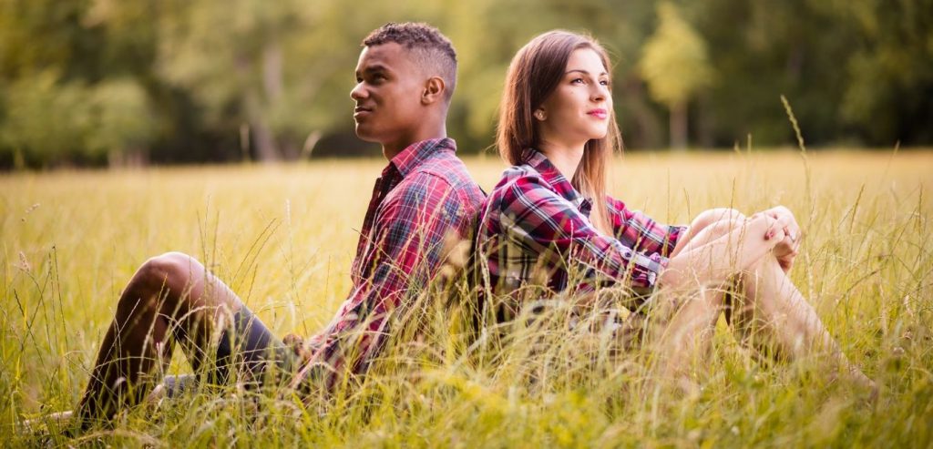 Online daters sitting in a field